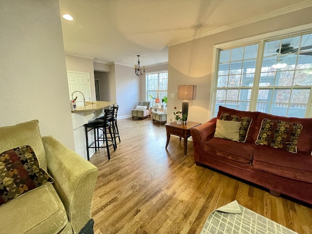 living room featuring light hardwood / wood-style floors, crown molding, and a chandelier