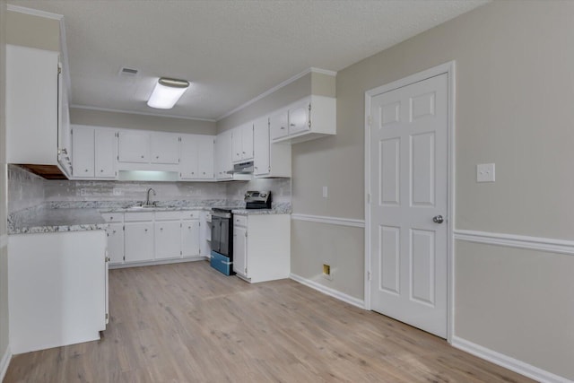 kitchen with light wood-style flooring, under cabinet range hood, light countertops, and range with electric stovetop