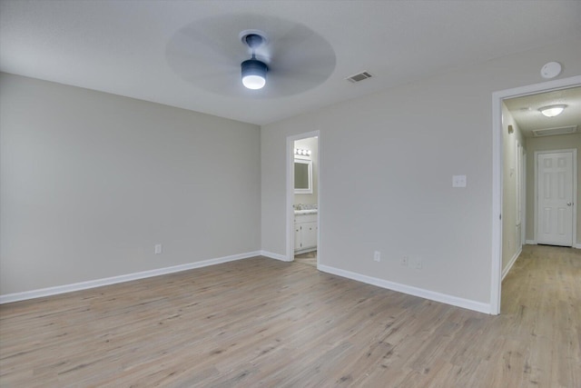empty room featuring visible vents, ceiling fan, light wood-style floors, and baseboards