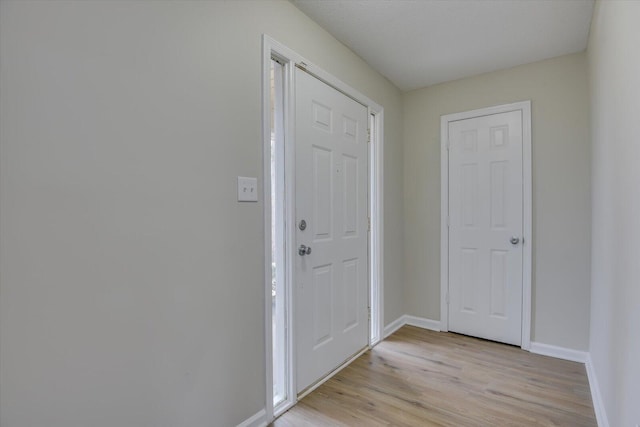 foyer entrance featuring baseboards and light wood finished floors