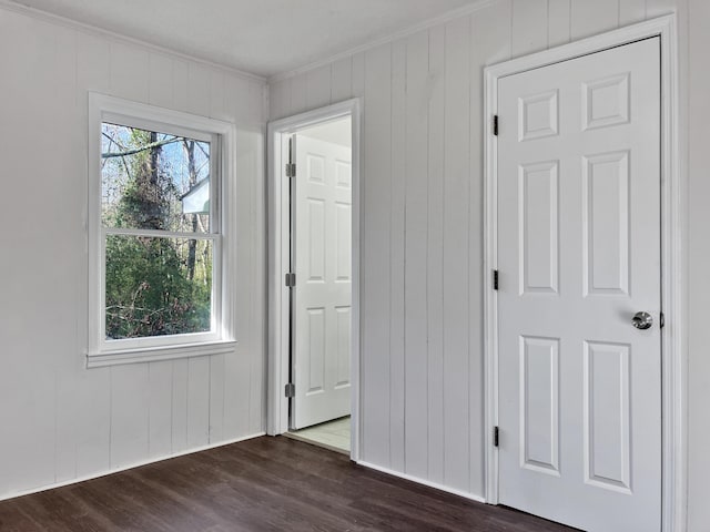 unfurnished bedroom featuring dark wood-type flooring and ornamental molding