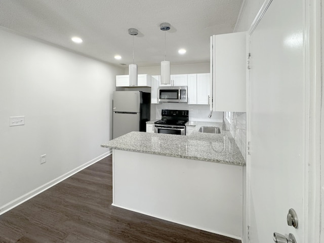 kitchen with decorative backsplash, appliances with stainless steel finishes, light stone counters, decorative light fixtures, and white cabinetry