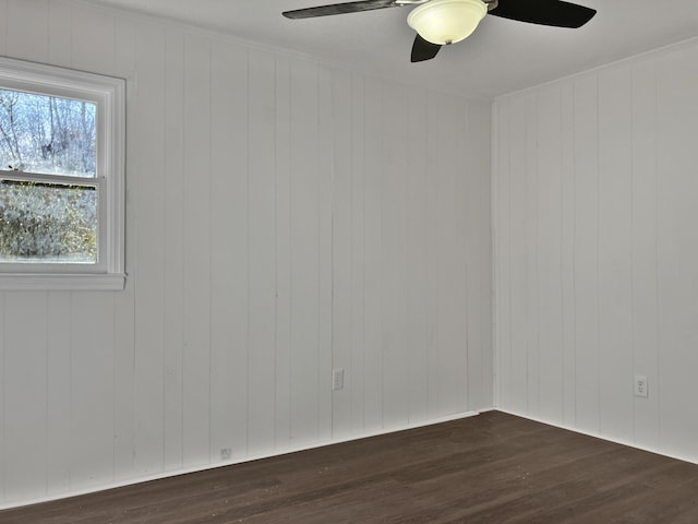 unfurnished room with dark hardwood / wood-style flooring, ceiling fan, and wooden walls