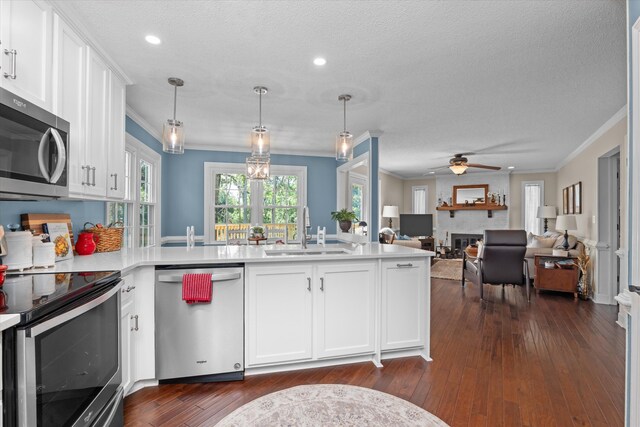 429 Cambridge Cir, Martinez, GA 30907 - kitchen featuring appliances with stainless steel finishes, ornamental molding, a peninsula, a textured ceiling, and white cabinetry