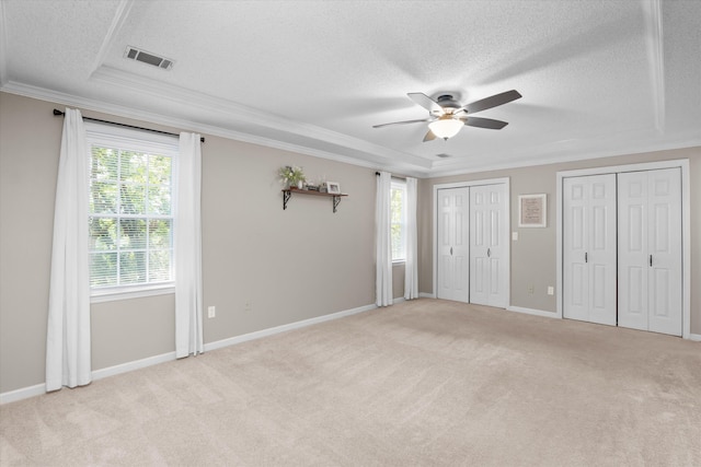 429 Cambridge Cir, Martinez, GA 30907 - unfurnished bedroom with a textured ceiling, crown molding, multiple windows, multiple closets, and light carpet