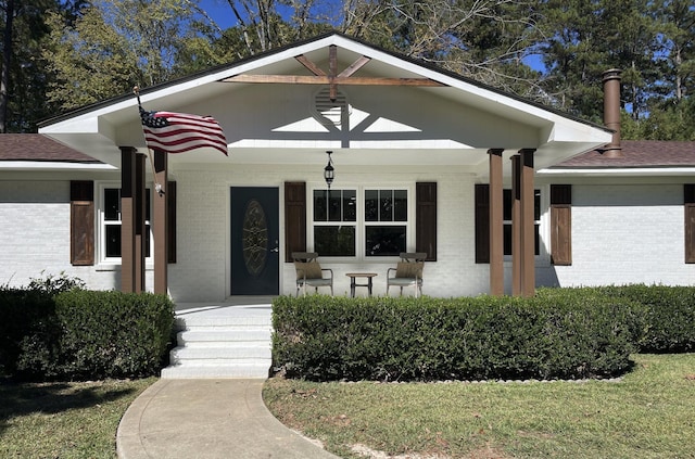 view of front of house with a porch and brick siding