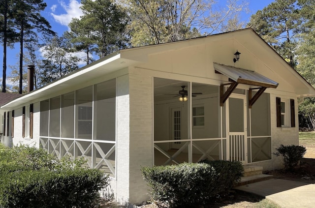 view of home's exterior with brick siding and a sunroom