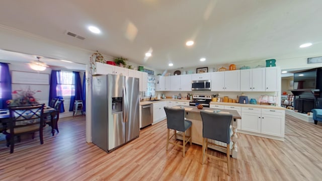 kitchen with light wood-style flooring, white cabinetry, and stainless steel appliances