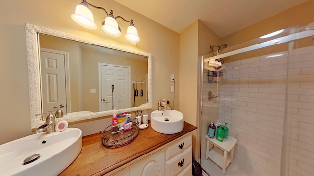 full bath featuring double vanity, a stall shower, and a sink