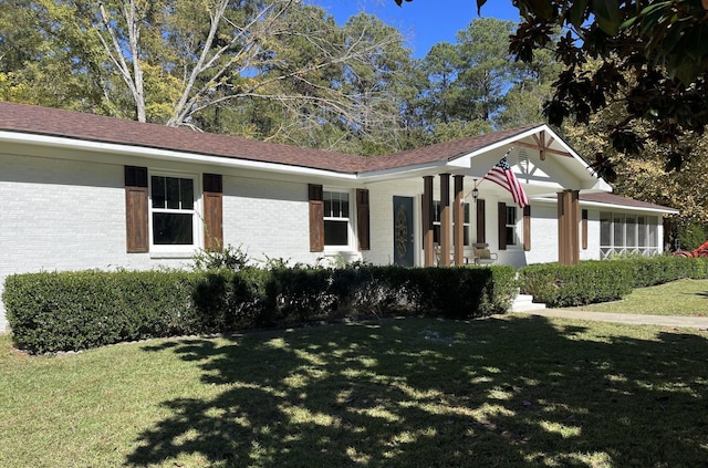 ranch-style house with brick siding and a front yard