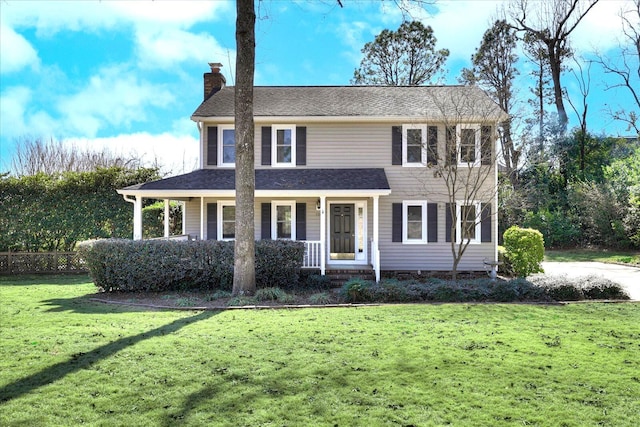 view of front facade with covered porch, a chimney, and a front lawn