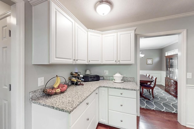 189 Mokateen Ave, North Augusta, SC 29841 - kitchen with dark wood finished floors, ornamental molding, white cabinetry, light stone counters, and a wainscoted wall