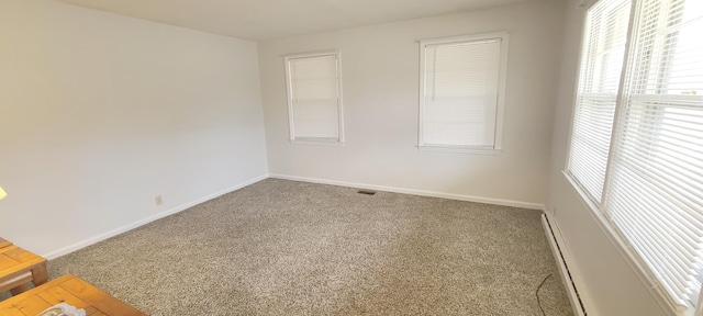 carpeted spare room featuring a baseboard radiator