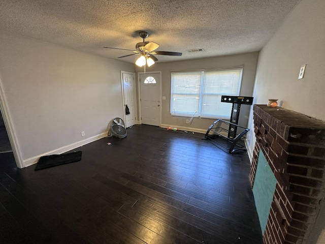 foyer entrance featuring ceiling fan, dark hardwood / wood-style floors, and a textured ceiling