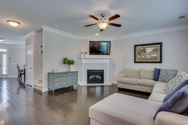 living room with a fireplace, dark wood-type flooring, ceiling fan, and ornamental molding