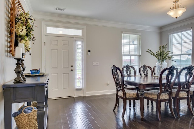 dining room featuring plenty of natural light, crown molding, and dark wood-type flooring