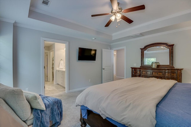 carpeted bedroom with a raised ceiling, connected bathroom, ceiling fan, and crown molding