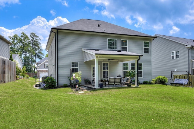 rear view of house with ceiling fan, a patio area, and a lawn