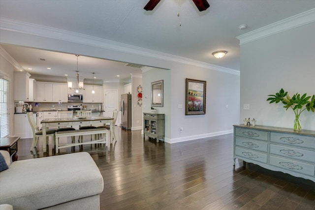 living room featuring ceiling fan, dark hardwood / wood-style flooring, and crown molding