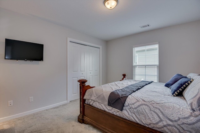 bedroom featuring light colored carpet and a closet