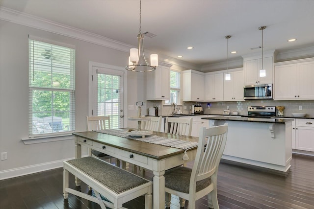 dining area featuring dark hardwood / wood-style floors, crown molding, plenty of natural light, and a notable chandelier