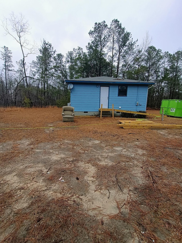 rear view of property with entry steps and crawl space