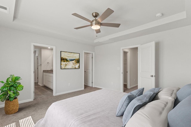 bedroom with visible vents, baseboards, connected bathroom, carpet, and a tray ceiling