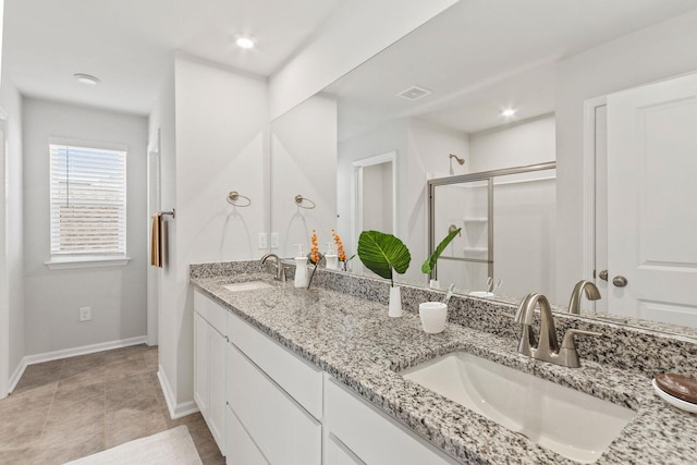 bathroom with a stall shower, visible vents, a sink, and double vanity