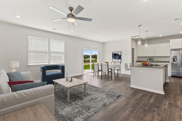 living room featuring dark wood-type flooring, recessed lighting, visible vents, and baseboards