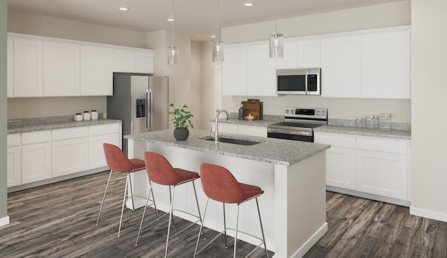 kitchen featuring recessed lighting, a sink, appliances with stainless steel finishes, dark wood-style floors, and a center island with sink