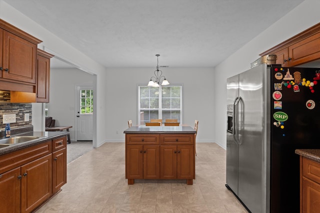 3430 Grove Landing Cir, Grovetown, GA 30813 - kitchen featuring stainless steel refrigerator with ice dispenser, dark countertops, brown cabinets, and a chandelier