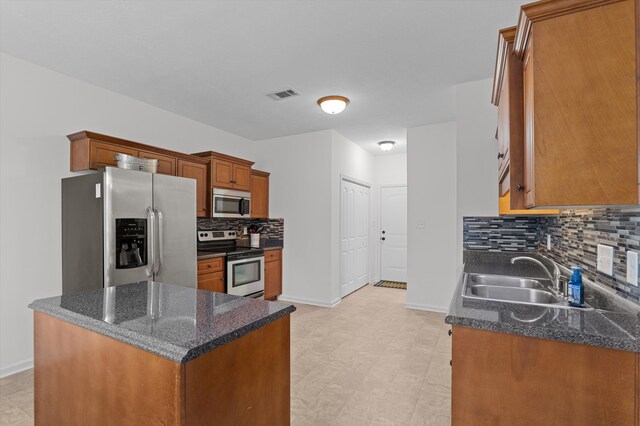 3430 Grove Landing Cir, Grovetown, GA 30813 - kitchen featuring appliances with stainless steel finishes, a sink, backsplash, baseboards, and brown cabinets