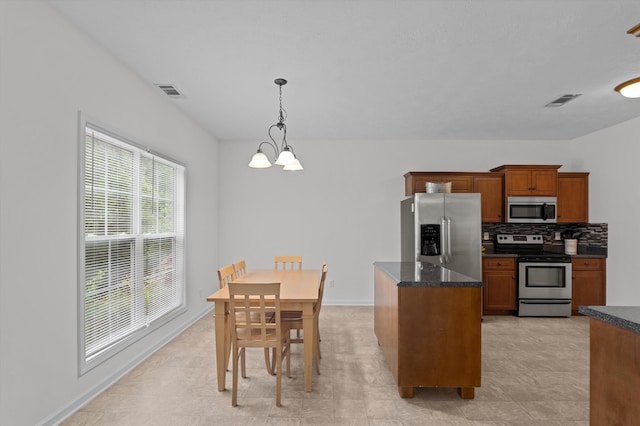 3430 Grove Landing Cir, Grovetown, GA 30813 - kitchen with appliances with stainless steel finishes, brown cabinets, tasteful backsplash, a chandelier, and hanging light fixtures