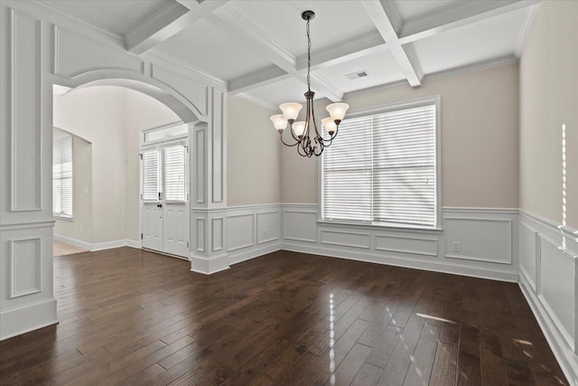 unfurnished dining area featuring dark hardwood / wood-style floors, ornamental molding, a chandelier, beam ceiling, and coffered ceiling