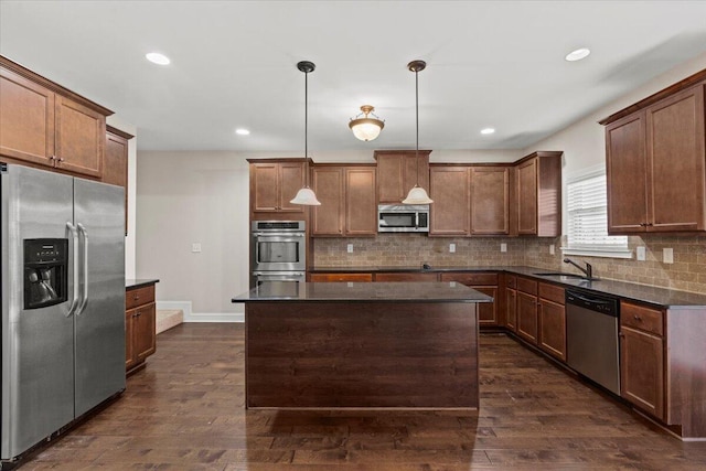 kitchen with a center island, decorative light fixtures, dark hardwood / wood-style flooring, stainless steel appliances, and sink