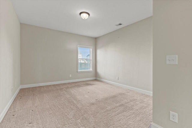 spare room featuring light colored carpet