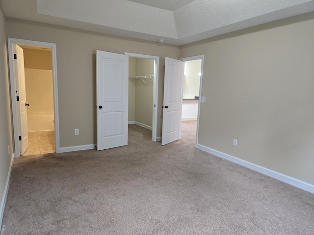 412 York Ln, Augusta, GA 30909 - unfurnished bedroom with carpet floors, a raised ceiling, a walk in closet, a closet, and ensuite bath