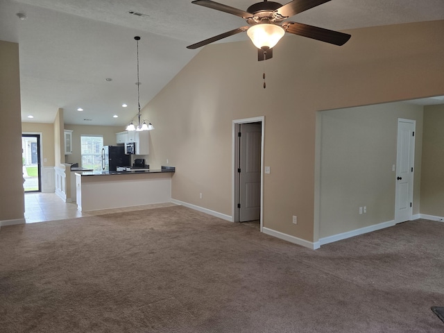 412 York Ln, Augusta, GA 30909 - unfurnished living room featuring light carpet, high vaulted ceiling, a ceiling fan, recessed lighting, and a chandelier