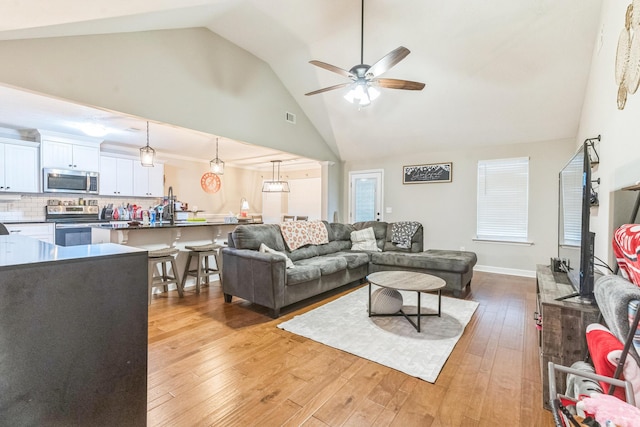 7105 Summerton Dr, Augusta, GA 30909 - living area with visible vents, baseboards, a ceiling fan, light wood finished floors, and high vaulted ceiling
