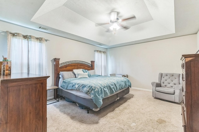 7105 Summerton Dr, Augusta, GA 30909 - bedroom featuring ceiling fan, a tray ceiling, visible vents, light carpet, and baseboards