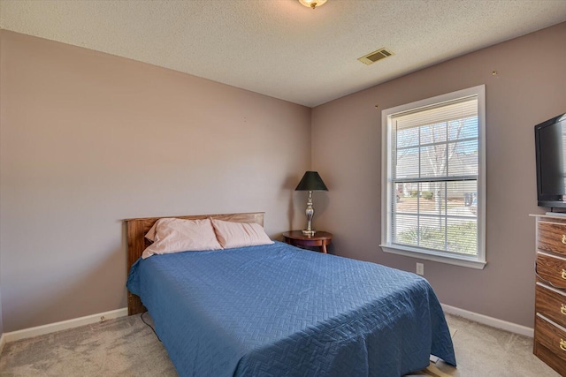 bedroom featuring baseboards, a textured ceiling, visible vents, and light colored carpet