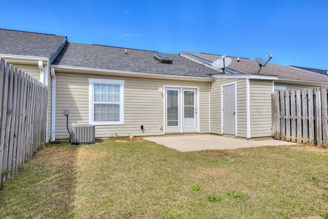 rear view of property with a patio, a fenced backyard, central air condition unit, a yard, and roof with shingles