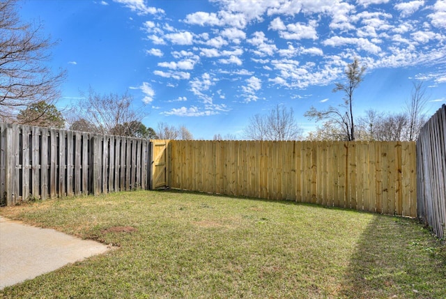 view of yard featuring a fenced backyard and a gate