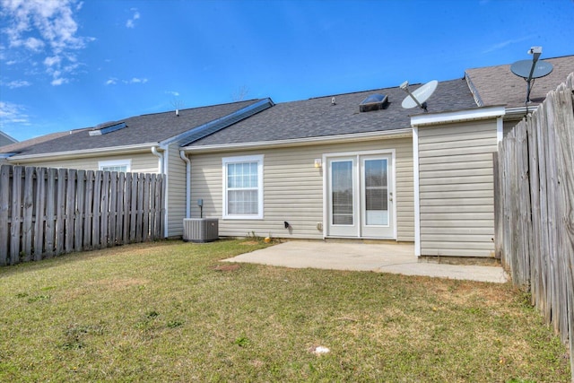 rear view of property with a patio, central AC unit, a fenced backyard, a yard, and roof with shingles