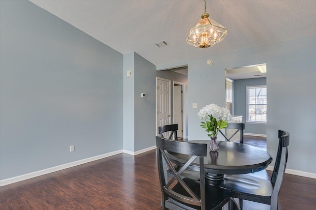 dining area with a notable chandelier, wood finished floors, visible vents, and baseboards