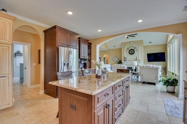 139 Laurens Dr, Mccormick, SC 29835 - kitchen featuring arched walkways, stone tile flooring, stainless steel fridge, ceiling fan, and crown molding