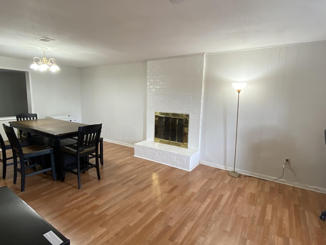 3406 Pine Hill Rd, Hephzibah, GA 30815 - dining space with baseboards, a fireplace, light wood-style flooring, and a chandelier