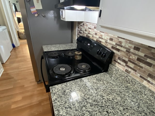 3406 Pine Hill Rd, Hephzibah, GA 30815 - kitchen featuring decorative backsplash, under cabinet range hood, white cabinets, light wood-style flooring, and black / electric stove