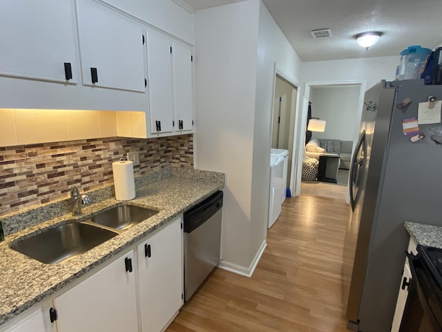 3406 Pine Hill Rd, Hephzibah, GA 30815 - kitchen featuring a sink, light wood-style flooring, stainless steel appliances, visible vents, and washing machine and dryer