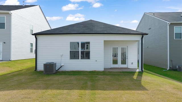 back of property with a patio, a lawn, central AC, and roof with shingles